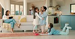 Love, hug and father with his wife and children in the living room of their modern house. Happy, playful and girl kids playing with their dad with their mother relaxing on a sofa in their family home