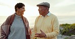 Sunset, funny and elderly couple walking on beach, bonding and talk on holiday. Happy, senior man and woman at sea, laughing and enjoying quality time together on vacation outdoor at ocean with love