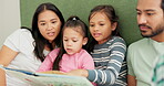 Mother, father and children reading a book on a bed in a family home for learning, quality time and bonding. A man, woman and girl kids in a bedroom together for a story and development with love