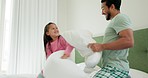 Man, girl and pillow fight in bedroom, fun and bonding with love and happiness at family home. Father, young daughter and playing game, energy and playful with action, care free and entertainment