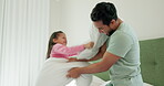 Father, daughter and pillow fight in bedroom, fun and bonding with love and happiness at family home. Man, young girl and playing game, energy and playful with action, care free and entertainment