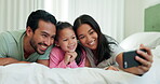 Mother, father and child on a bed for a selfie in a family home for happiness, quality time and bonding. A man, woman and girl kid in a bedroom together for a profile picture with love and care