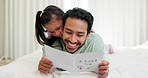 Father, child and greeting card in a family home with love on bed for message and art on paper. Man and girl kid in bedroom for drawing development, surprise and gratitude on birthday celebration
