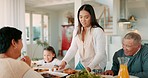 Thanksgiving, food and a woman serving her family a meal during a celebration together for bonding. Love, brunch or roast lunch with a mother carrying chicken to relatives at the dining room table