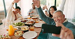 Thanksgiving, wave and video call with a grandfather and his family together for bonding in celebration. Love, lunch or brunch with a senior man and relatives taking a selfie at the dining room table