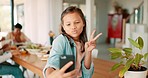 Selfie, peace or profile picture and a girl in a home, posing with her family on a blurred background. Kids, social media and hand gesture with a happy young female child taking a photograph