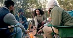 Camping, fire and friends with marshmallow in nature for holiday, vacation and adventure in woods. Friendship, happy and men and women with snack by bonfire for bonding, quality time and relax 