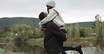 Couple, man lifting woman with hug and happiness outdoor, love and commitment, trust and safety together. Bonding, support and care, man and woman on date in nature park with happy youth in forest