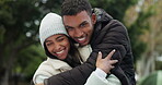 Young couple, hug and happiness outdoor with love and commitment, trust and safety together. Bonding, support and care with date in nature, man and woman in park with happy youth and embracing