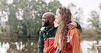 Hike, interracial couple and hug on adventure by a lake together with a smile on travel journey. Happy, young people and outdoor holiday in nature while walking on a vacation with love and talk