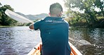 Lake, camping and man in kayak from back, rowing and summer adventure in nature for sports, fun and hobby. Row boat, canoe and camp counsellor on river in trees, water and freedom on outdoor vacation