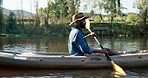 Lake, camping and black man in kayak, rowing and summer adventure in green nature for sports, fun and hobby. Paddle boat, canoe and camper on river with trees, water and freedom on outdoor vacation.