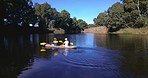 Lake, camping and drone shot of men in kayak together, summer adventure and nature for sports, fun and hobby. Rowing boat, canoe and friends on river with trees, water and freedom on outdoor vacation