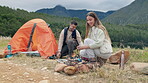 Campfire, couple and help with tent in nature for vacation, holiday and travel outdoor. Camping, forest and happy man and woman in woods together for adventure, hiking and trekking in the countryside