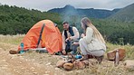 Couple, outdoor camping and pitch tent with rock, adventure and fire in mountains, forest and holiday. Man, woman and building shelter on ground for safety, vacation and teamwork with talking in bush