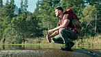 Bottle, hiking or man by river water in nature adventure to explore outdoors for camping on holiday vacation. Traveller, lake or thirsty hiker trekking collecting liquid for travel, break or journey
