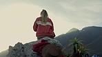Woman, mountaintop and sitting on rock, hiking or relax for view, peace or trekking in nature on vacation. Girl, back and holiday in mountains for fitness, health or mindfulness on cliff in Argentina