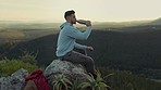 Hiking, view of mountain and man drinking water, relax on outdoor adventure and freedom in nature. Trekking landscape, rock climbing and hiker sitting with bottle, horizon and motivation to travel.