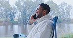 Man, camping and phone call in nature, lake or woods communication and outdoor conversation at travel location. Talking, funny and mobile chat of happy person or camper relax in chair by forest river