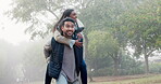 Couple, piggy back and love in the park with a smile, happy date or people together for fun in nature, woods or walk in the forest. Friends, Indian woman and man have quality time to play on vacation