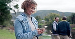 Happy, typing and woman with a phone in nature for communication, social media or a chat. Smile, email and a young girl with a mobile for an app notification, conversation or search online at a park