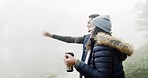 Couple, camping and coffee with talking, forest and pointing with direction, fog and winter morning on vacation. Man, woman and walking outdoor with conversation, warm drink and romance in woods