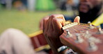 Man, playing and guitar with hands in outdoor with sound for entertainment or to relax on vacation. Sound, guy and instrument in nature for calm in close up with blurry background in environment.
