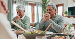 Senior man, woman and praying for food at dinner table with big family at home. Group of people in worship, prayer or thanks for eating lunch meal, respect or gratitude in dining room at thanksgiving