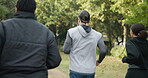 People, personal trainer and running in park for cardio exercise, workout or training together outdoors. Rear view of coach in team motivation for sports run, fitness or healthy wellness in nature