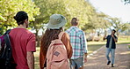 Back, walking and student friends on campus for a university tour of the college grounds together. School, education and orientation with a group of academic learners outdoor for higher learning