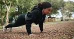 Woman, fitness and push ups in nature for workout, exercise or strength training in the outdoors. Determined female person exercising and lifting body on ground or floor for healthy wellness outside