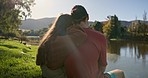 Back, hug and couple at a lake with for camping, bond and relax while exploring nature together. Behind, love and man embrace woman in a forest for hiking, travel or adventure, journey or outdoor