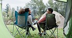 Tent, relax or couple camping in nature on holiday vacation or fun weekend break at countryside together. Chair, back or man with woman bonding, talking of speaking in park, forest or woods outdoors
