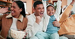 Family, popcorn and celebrate on a sofa at home to relax, bond and quality time. Excited men, women or parents and grandparents with child and tv remote in a living room for sports competition win