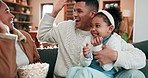 High five, celebrate and family with popcorn at home to relax, bond and support. Excited man, woman or parents with a happy child in a living room watching tv for sports competition or game for win