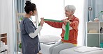 Elderly woman doing exercise with a resistance band for physical therapy with nurse in clinic. Fitness, healthcare and female patient doing arm workout with a physiotherapist in rehabilitation center