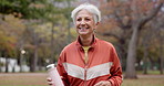 Fitness, senior woman and walking at park for healthy body, wellness or exercise with bottle. Smile, workout and elderly athlete outdoor, nature or garden for cardio, sport and travel for retirement