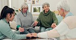 Senior group, holding hands and pray in elderly care for support, trust or unity in social gathering at home. Mature women touching in team activity, share or praying for hope in retirement together