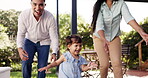 Happy, child or girl running from parents in outdoor garden, backyard or toddler laughing or playing on the deck of home with family. Mom, dad and excited kid together and run with happiness 