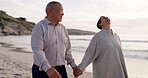 Senior couple, holding hands and walking on a beach outdoor at sunset for love, care and travel. Happy man and woman laugh together at ocean for retirement holiday or vacation while talking in nature