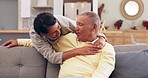 Happy, hug and senior couple on a sofa talking, bond and relax in their home together. Smile, love and old people embrace in a living room with conversation, romance and enjoy retirement or weekend