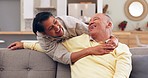 Senior couple hugging on a sofa laughing together at a comic, funny or comedy joke at home. Love, happy and elderly man and woman in retirement embracing, relaxing and bonding while in conversation.