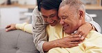 Happy, senior couple and sofa hug, bond and conversation, relax and chilling in their home together. Love, smile and old people with funny conversation, joke or silly humor while enjoying retirement 