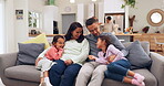 Family, parents and girl children on the sofa in the living room of their home for hugging or bonding. Smile, kiss or happy kids sitting together with their mom and dad for love, trust or support