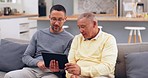 Tablet, conversation and man with his senior father on a sofa networking on social media together. Digital technology, living room and adult son helping his elderly dad browse the internet at home.