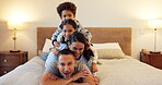 Happy, family together and portrait on a bed to relax, bond or play on holiday, vacation or parents with love for children. Bedroom, mom and kids on dad for funny memory, moment or lying in a pile