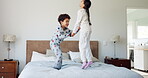 Happy, energy and jump with children in bedroom for morning, wake up and holding hands. Dance, happiness and fun with excited kids on bed in family home for celebration, freedom and support together