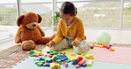 Kids, toys and teddy bear with a girl playing in her bedroom at home for learning, growth or child development. Children, building blocks and a young female adolescent having fun alone in her house