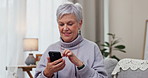 Senior woman, typing and cellphone on sofa with online app for communication with smile in home. Technology, reading and information with elderly female on website for streaming in living room.
