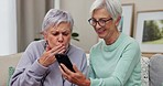 Senior friends, phone and video call, kiss and talking together in home living room sofa. Elderly, smartphone and happy women in virtual conversation, communication and speaking with love in house.